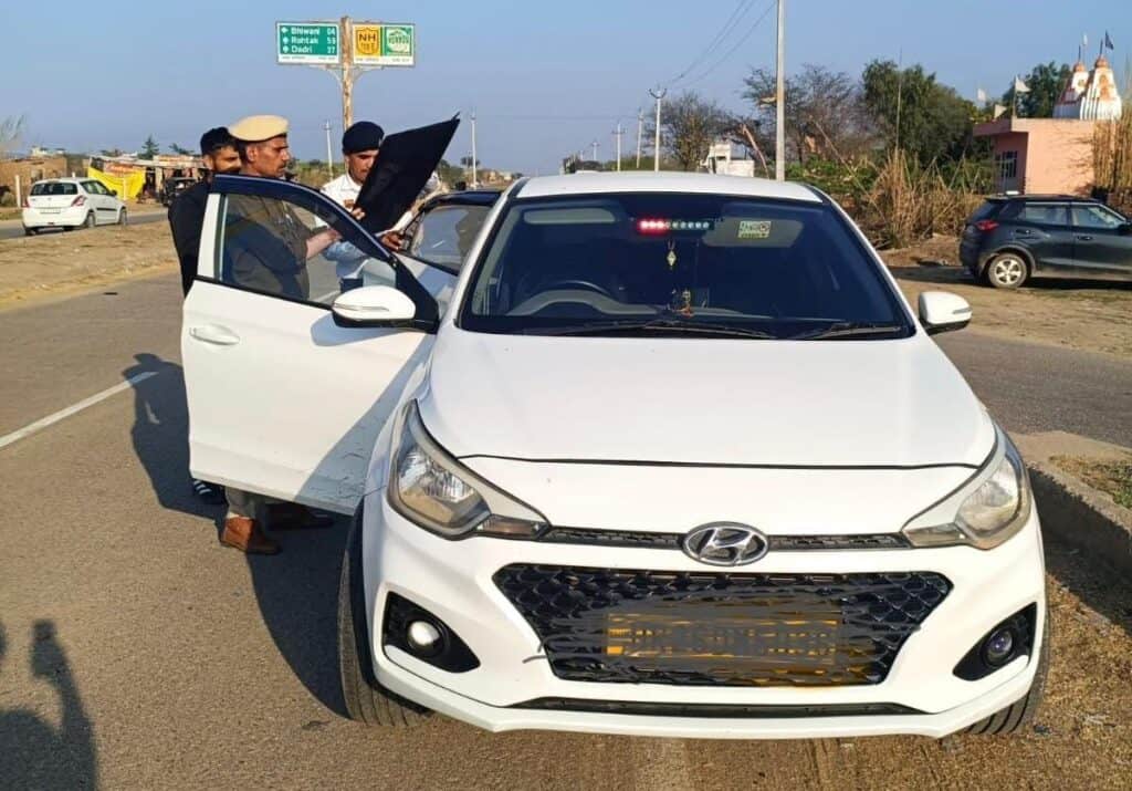 Traffic police officers checking vehicle documents during Haryana traffic enforcement.